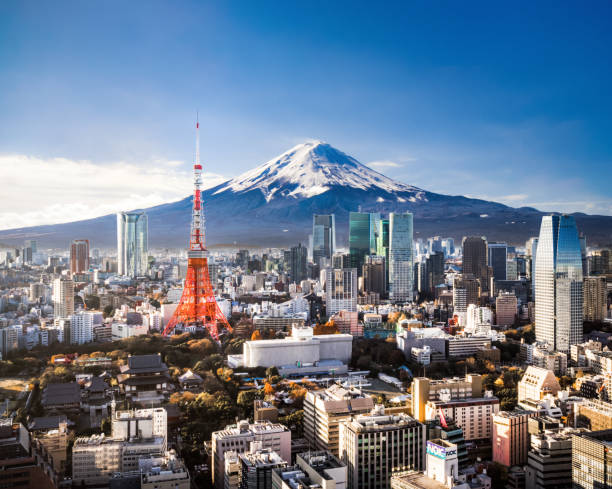 Aerial view of Mt. Fuji, Tokyo Tower and modern skyscrapers in Tokyo on a sunny day.